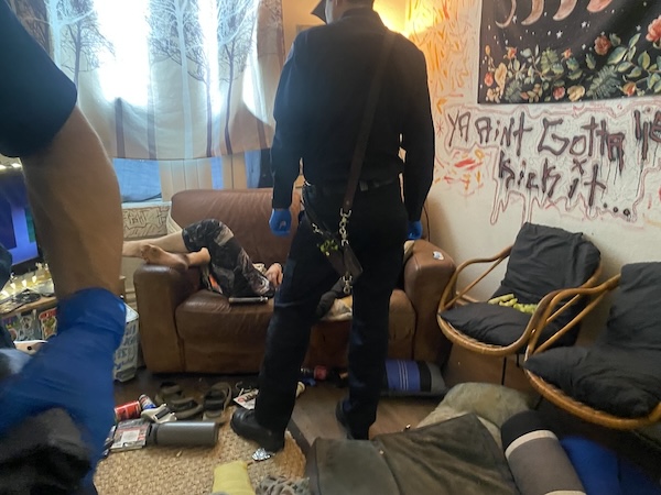 Trashed room with people.
