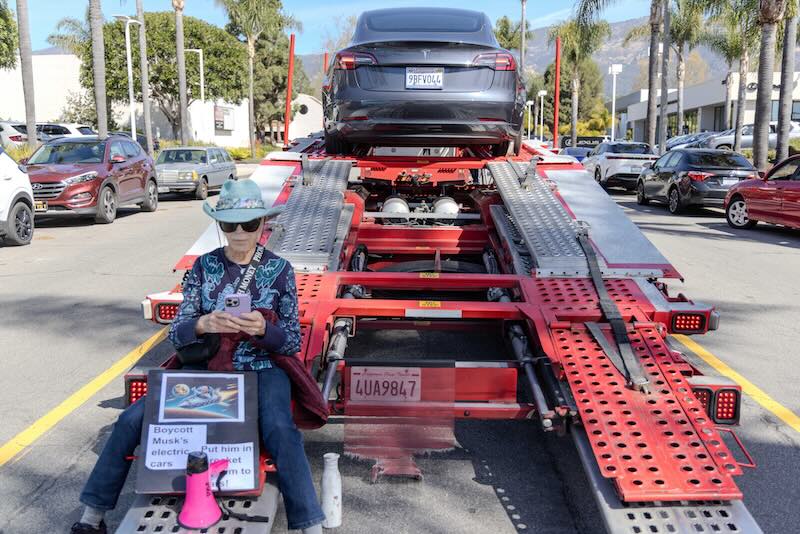 Protester sitting on auto hauler.
